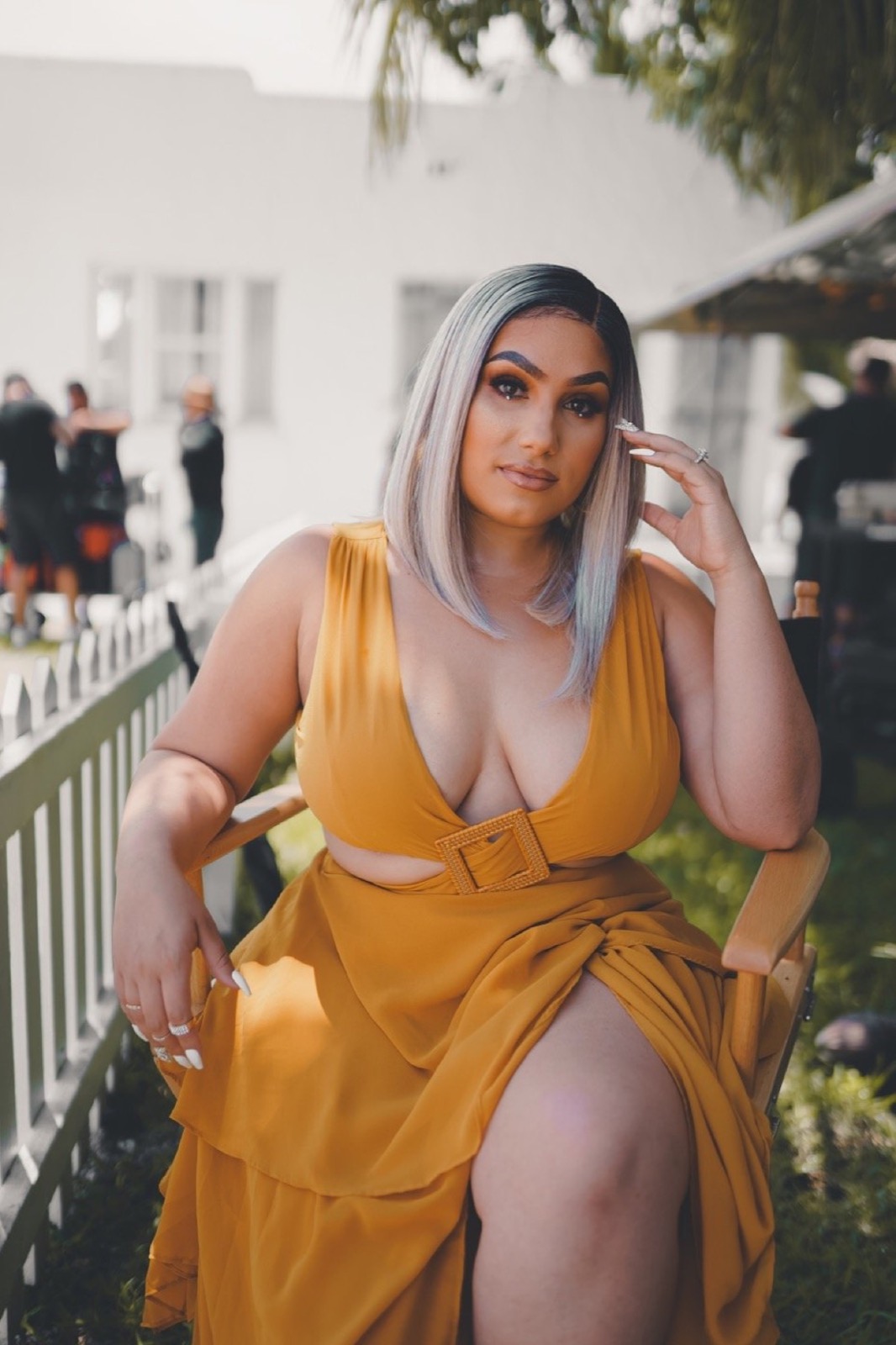 Music video still, yellow dress on a white porch