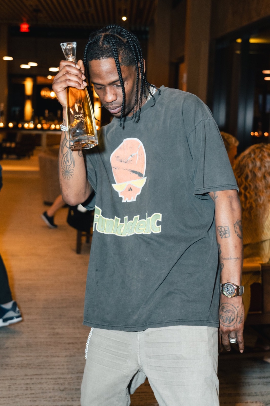 Musician holding up a tequila bottle at a night event