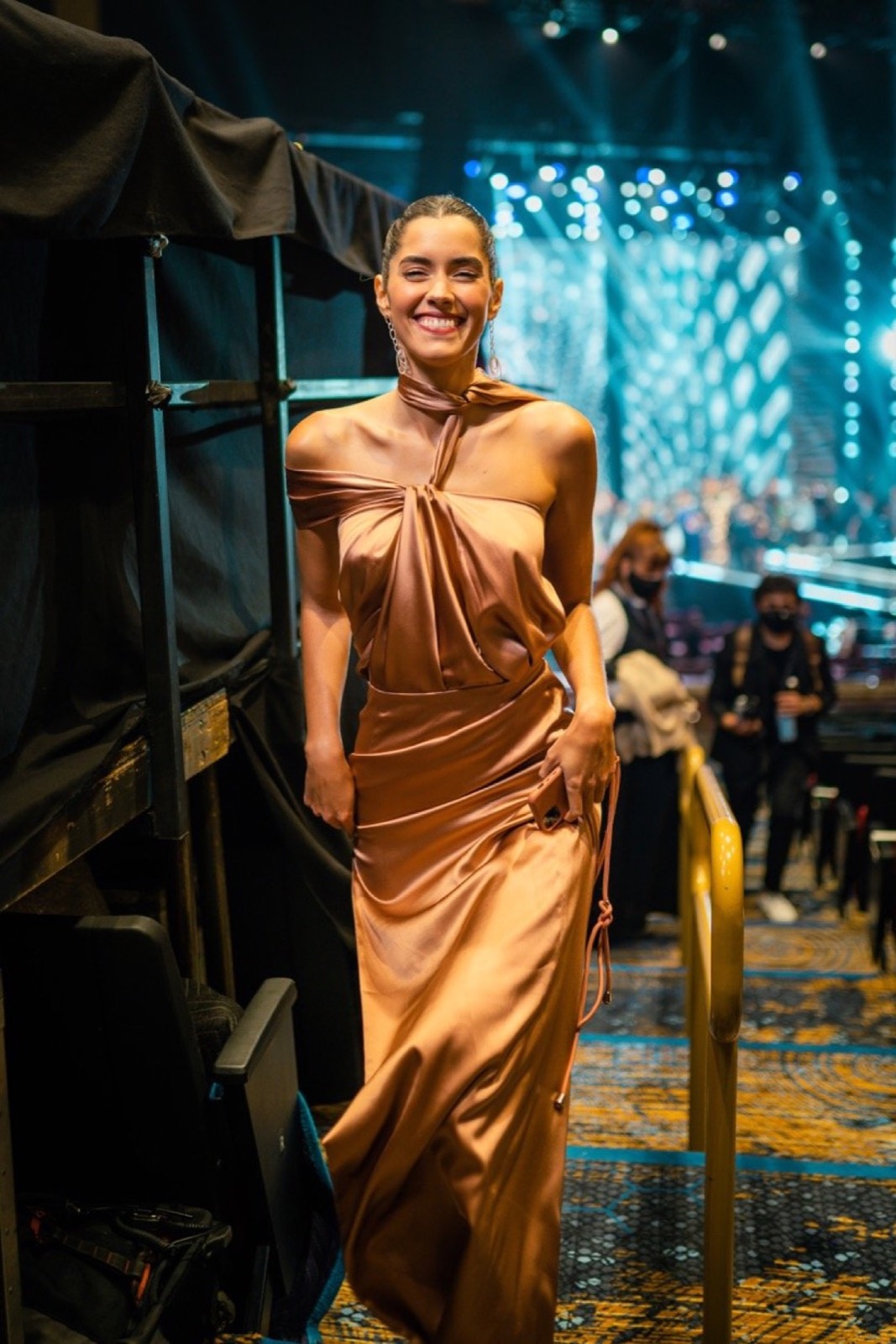 Model in a gold dress on a mirrored staircase