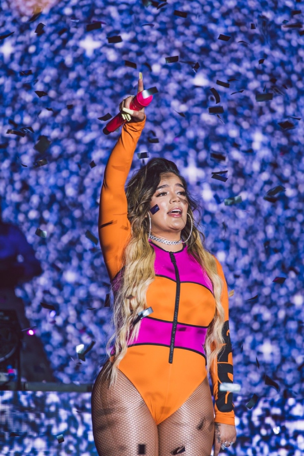 Performer with a raised fist on a glittering stage
