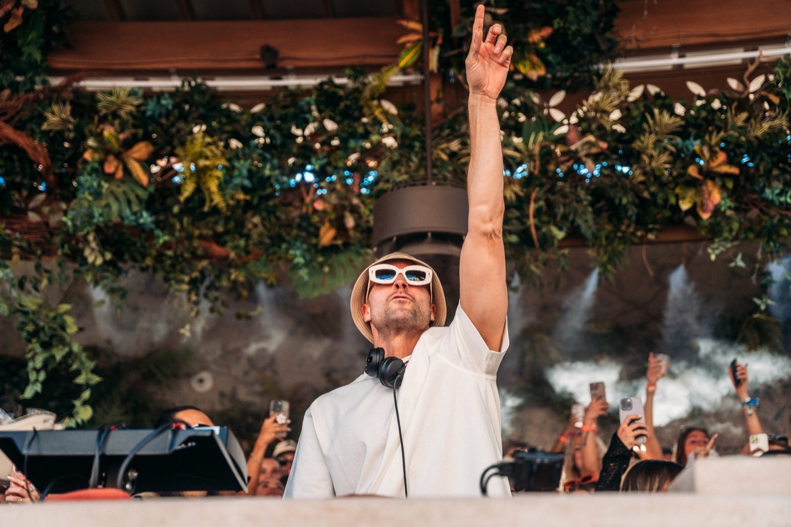 DJ under a canopy of greenery at a daytime set