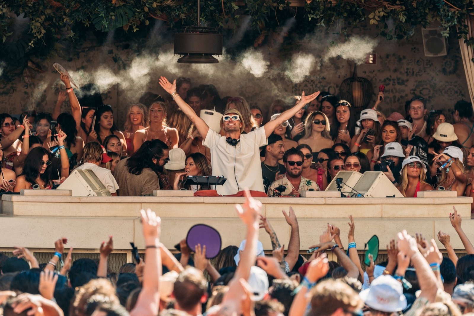Confetti and hands up at a beach club