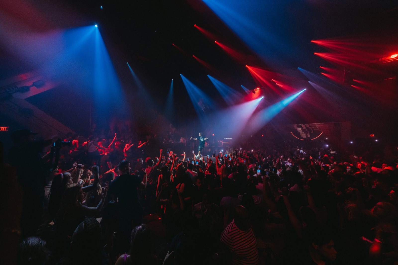 Festival crowd under red and blue stage lasers