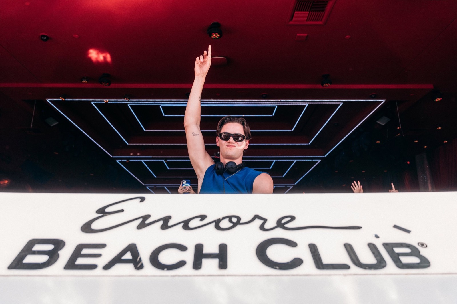 DJ waving above the Encore Beach Club sign