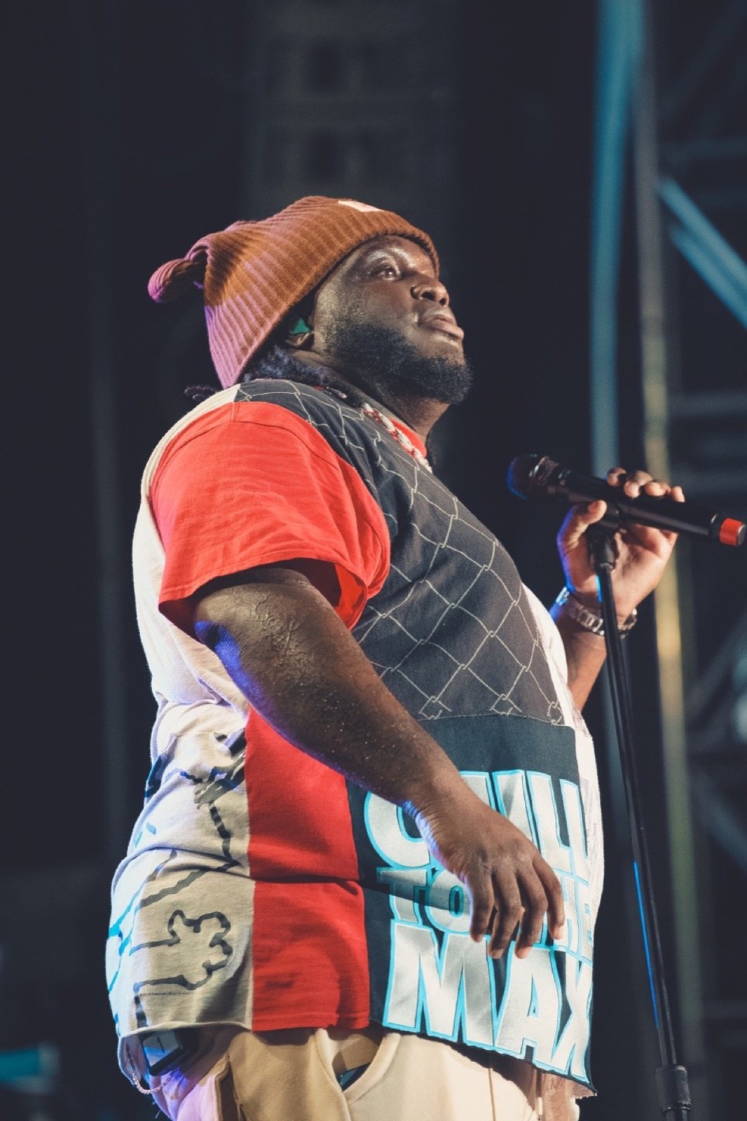 Rapper in a red beanie at the mic