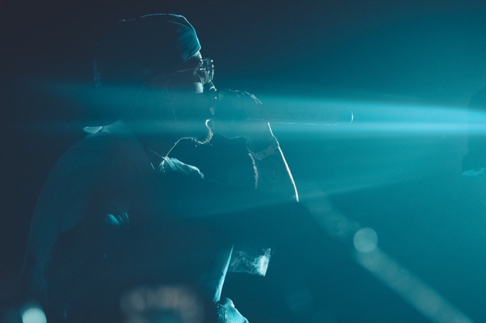 Artist silhouetted in teal haze